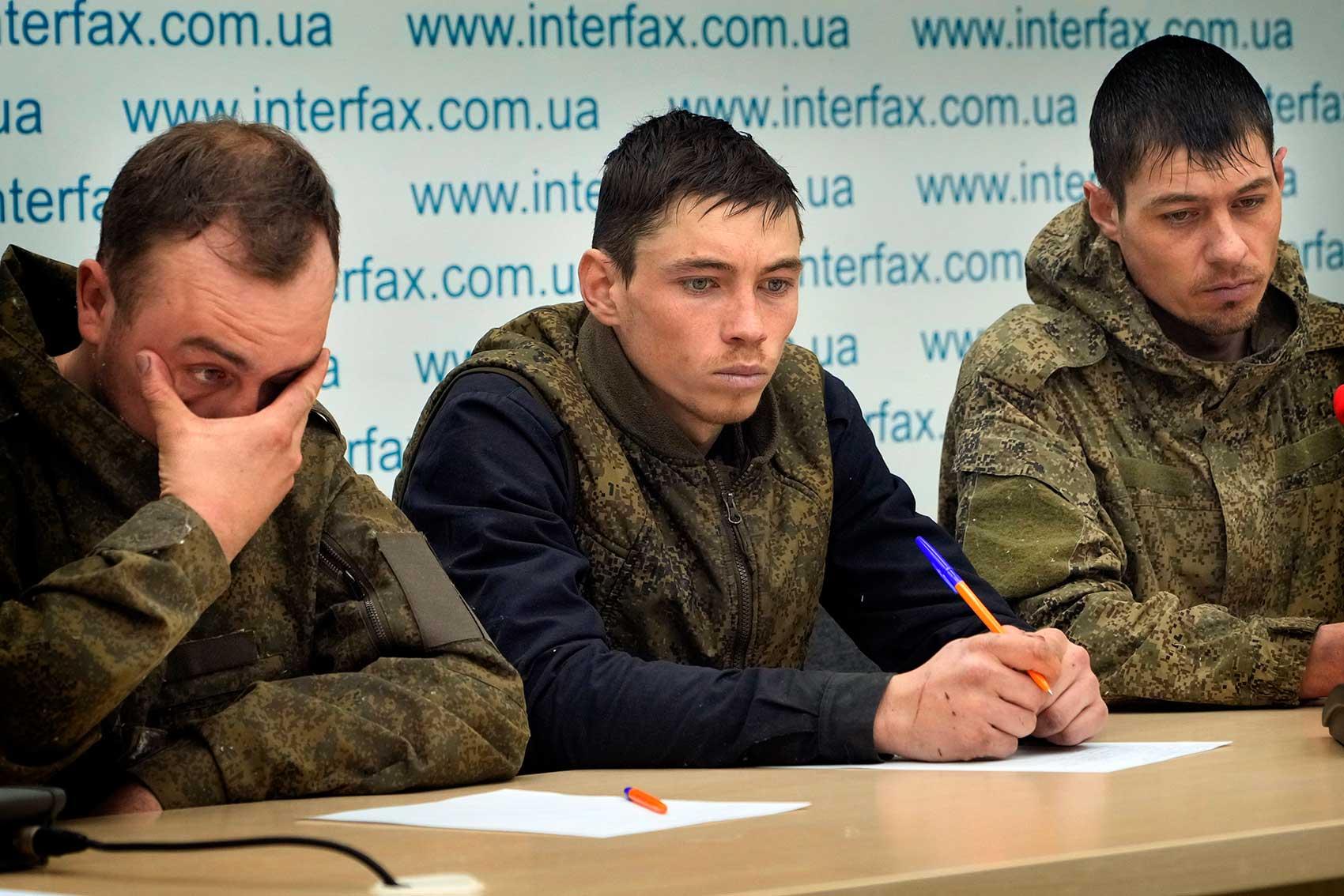 Three captured Russian soldiers sitting at table